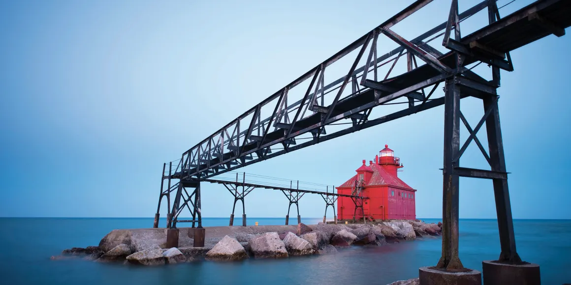 Roter Leuchtturm mit Brücke an einem schönen Morgen mit ruhiger See